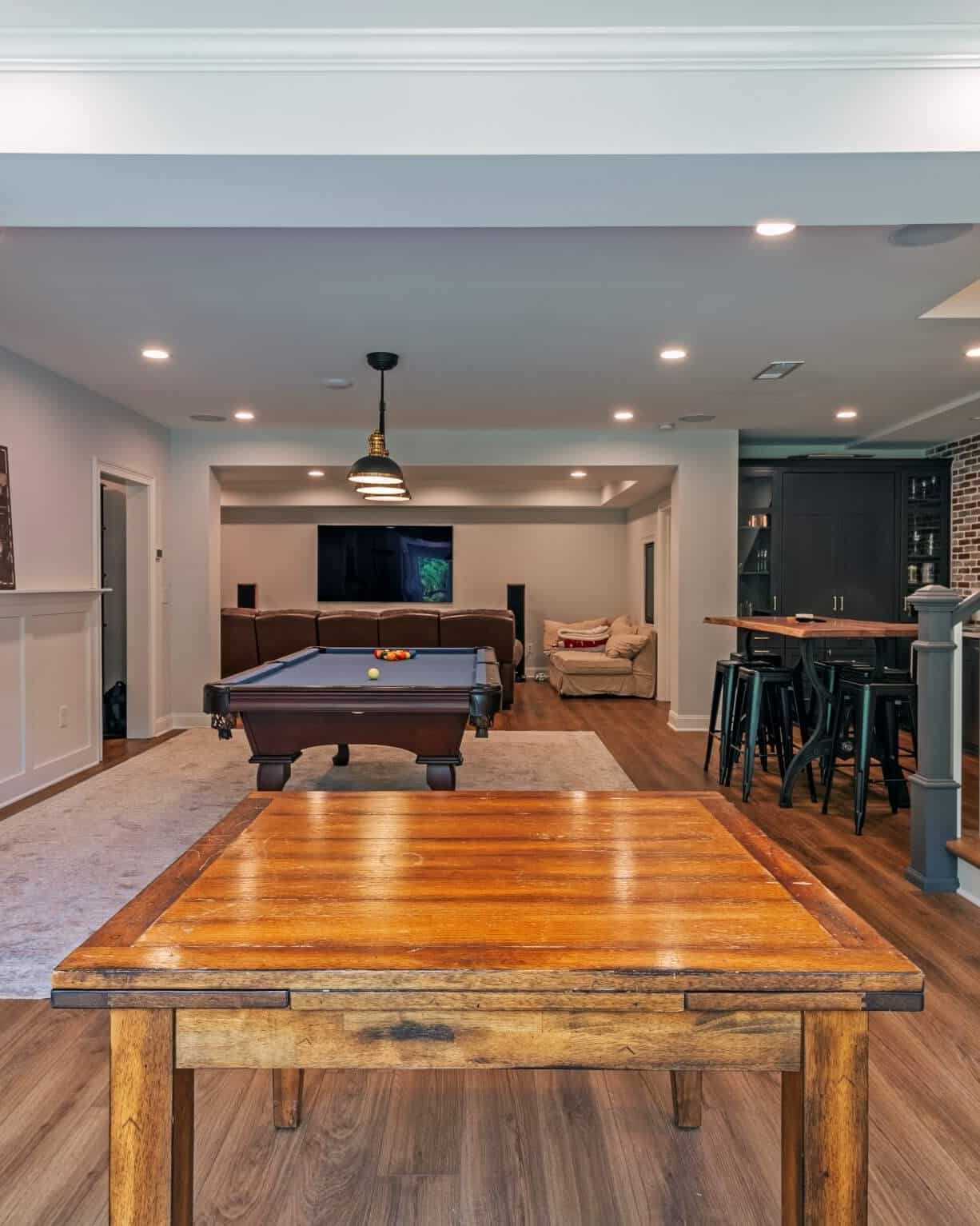 Wide finished basement with living area, recessed lighting and luxury vinyl flooring