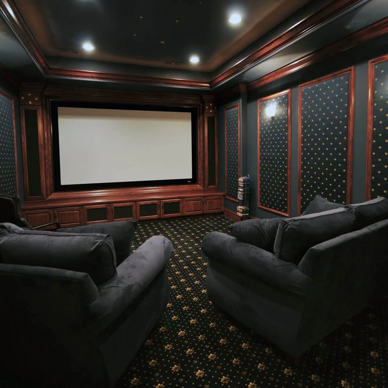 Basement home theater with a projection screen, cherry millwork and upholstered wall panels