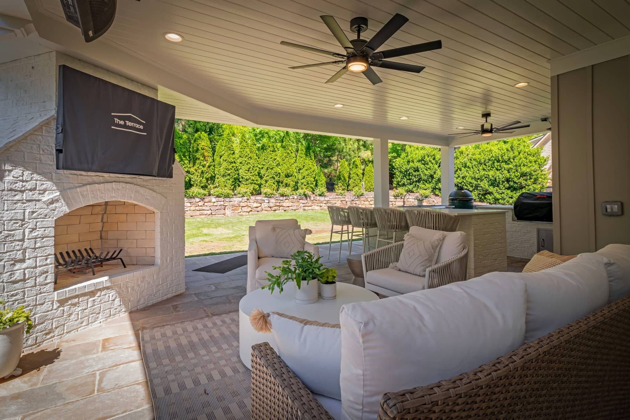 Covered terrace with white-brick fireplace, lounge seating and bar