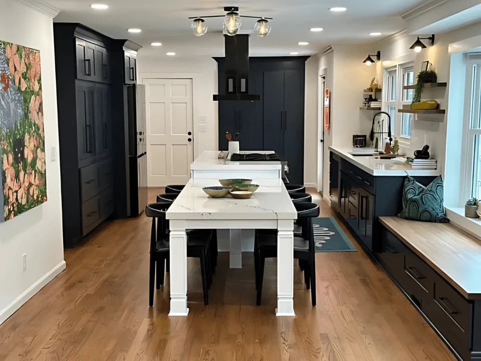 Remodeled kitchen with navy cabinetry, a white quartz island table and a built-in window seat